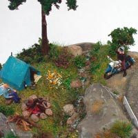 Zelt mit Lagerfeuer und Motorradfahrer, der den Helm abnimmt